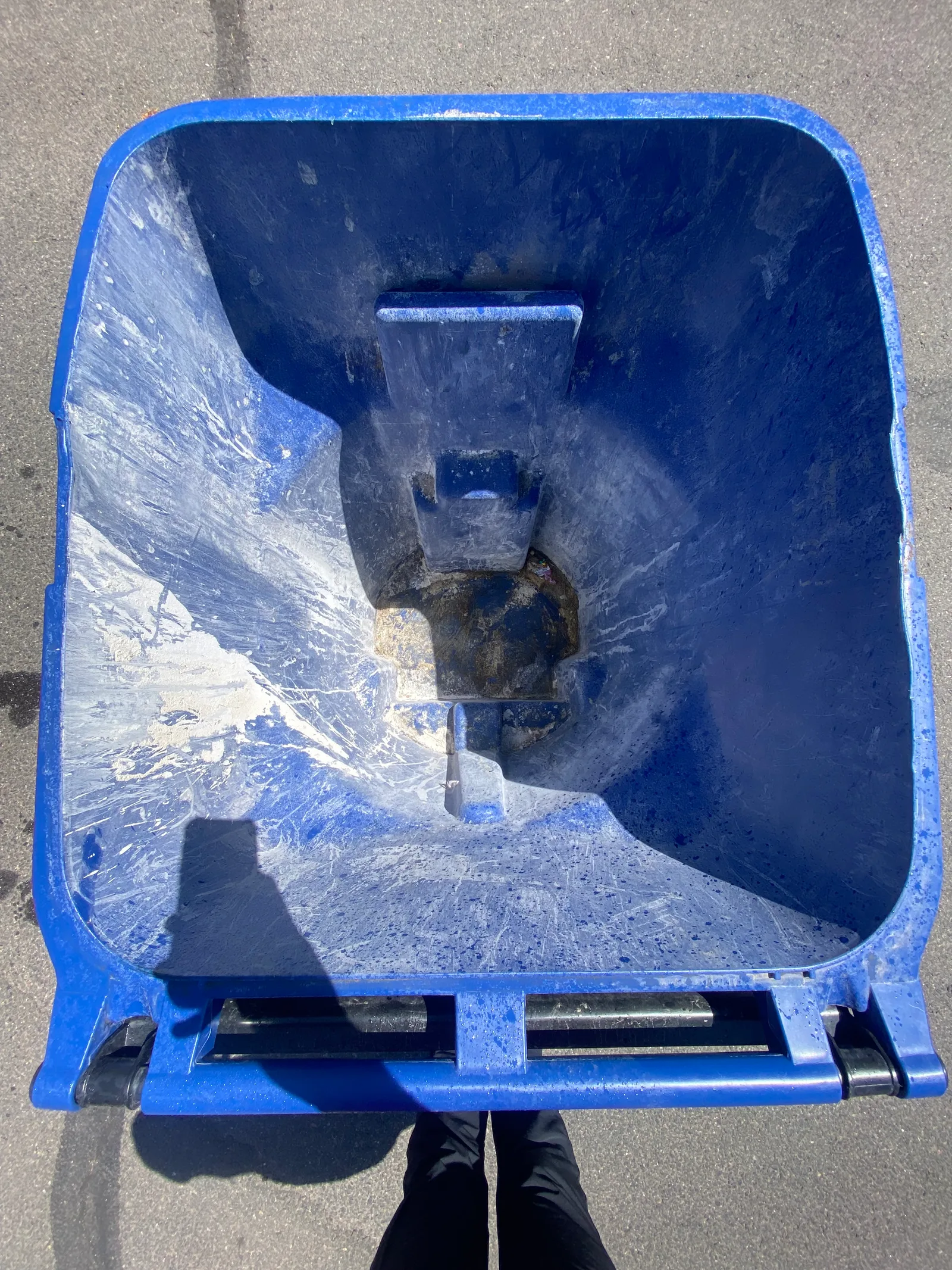 Black trash and blue recycling bins at the curb with grime and stains before Britebin cleaning