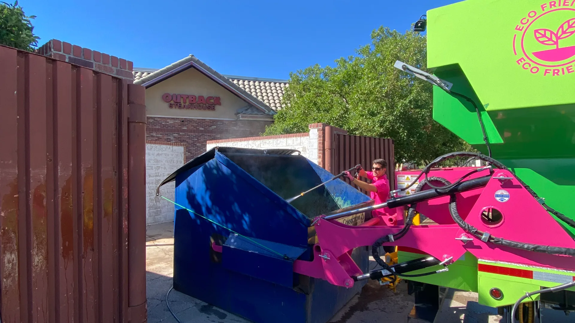 Commercial dumpster and pad after container cleaning and surface washing